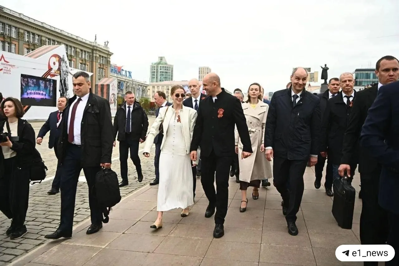 Во время шествия «Бессмертный полк» в Екатеринбурге и парада Победы в Верхней Пышме рядом с полпредом заметили женщину в люксовых аксессуарах: балетки Chanel, кольцо Cartier, сумка Louis Vuitton и платье Sandro.