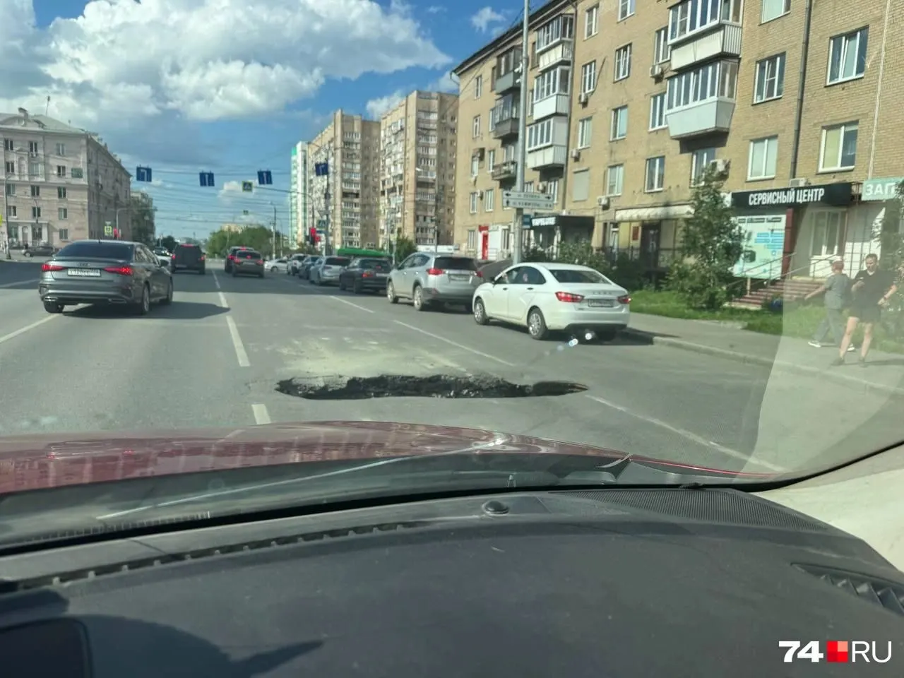 Яма рядом с проспектом Ленина растянулась почти на всю ширину полосы; водители выставили канистру, чтобы предупредить проезжающие машины.